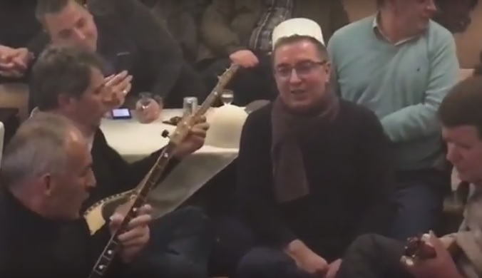 Deputeti i LSI këmbëkryq në sofër, këndon me rapsodët me çifteli (VIDEO)