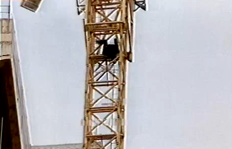 Një person tenton të hidhet nga vinçi në një pallat pranë kishës