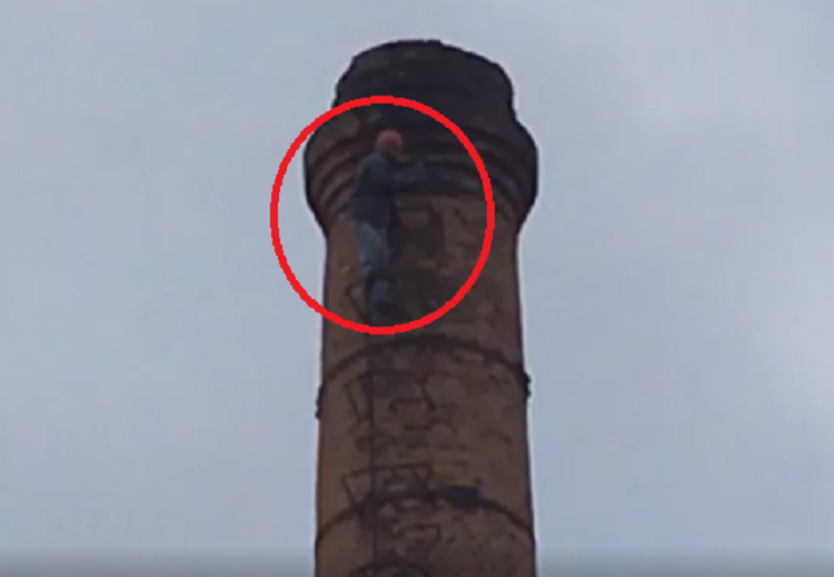 Një person hipën në majë të oxhakut dhe kërcënon me vetëvrasje