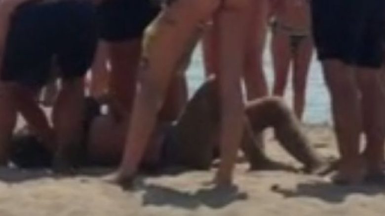 Pushuesi vdes poshtë çadrës në plazh