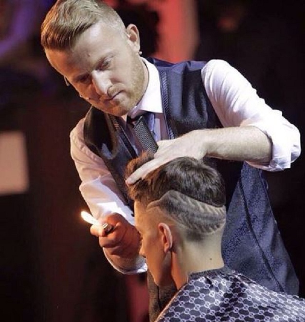 Berberi shqiptar që pret flokët me djegie, sy mbyllur dhe tre gërshërë