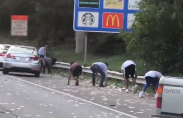 Paratë derdhen në autostradë, shoferët në garë për t’i mbledhur (VIDEO)