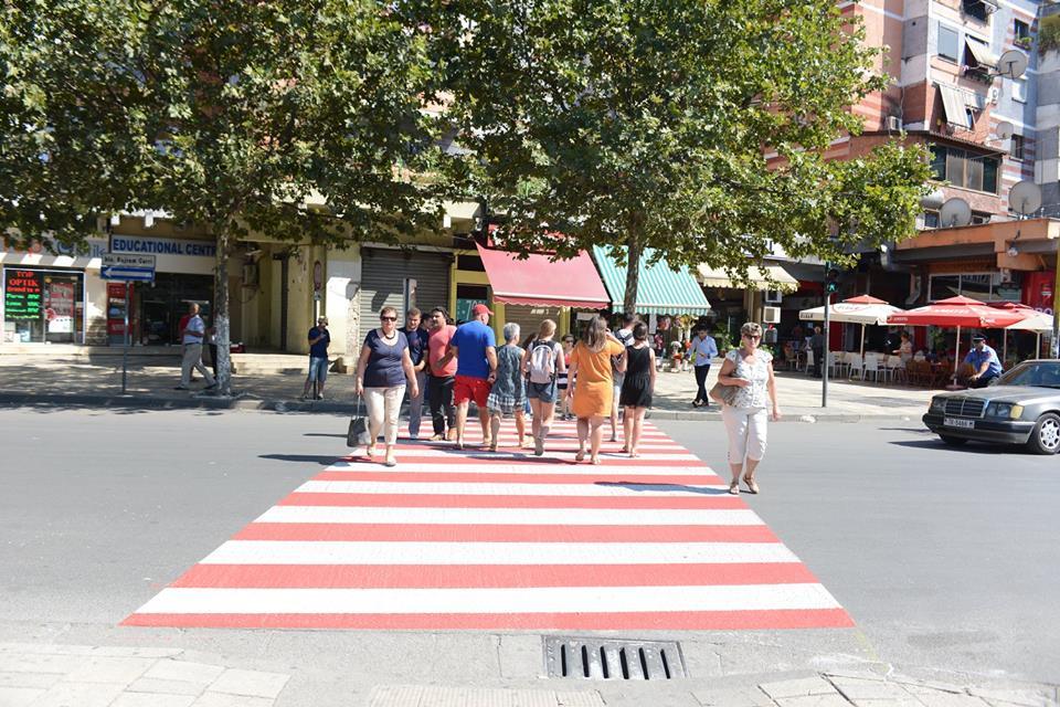 Makina i zë poshtë këmbën kalimtares te vijat e bardha