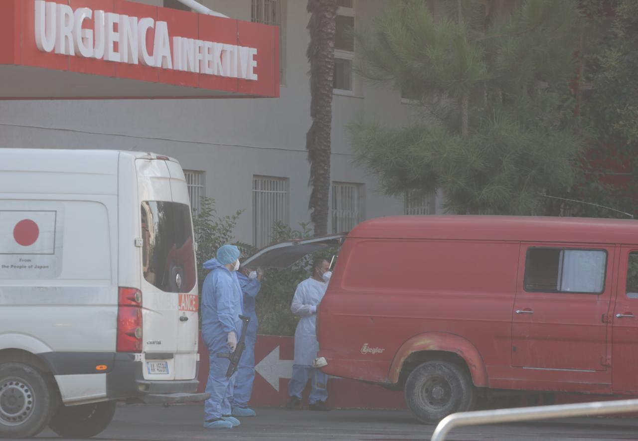 Një polic i veshur me veshje speciale dhe automatik në dorë, si transportohet e burgosura me COVID tek Infektivi