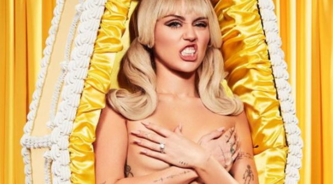 Miley Cyrus shokon sërish, pozon e zhveshur në një arkivol të verdhë