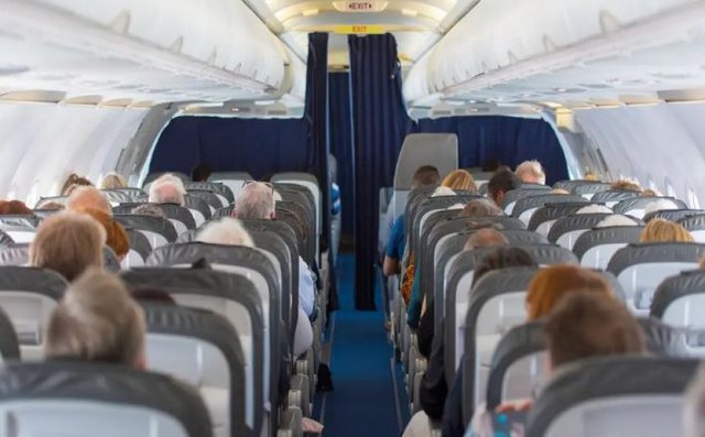 Panik në ajër, një person tenton të hapë derën e avionit