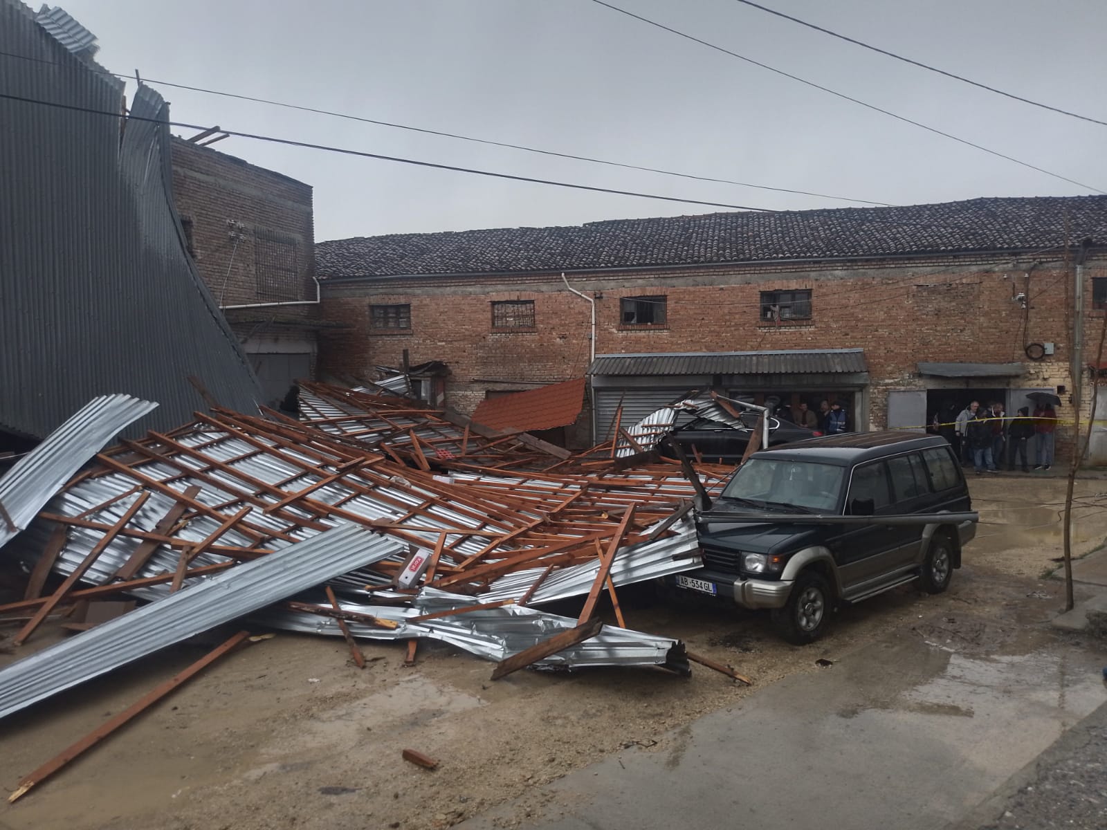 Era e fortë rrëzon çatinë e një magazine ushqimore, dëmtohen pesë makina të parkuara pranë objektit